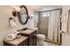 Bathroom featuring vanity, granite countertop, framed mirror, and tiled shower at 8258 Cherokee St, Denver, CO 80221