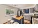 Modern kitchen with stainless steel appliances, butcher block island, and ample natural light streaming through the window at 8258 Cherokee St, Denver, CO 80221