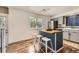 Bright kitchen featuring butcher block island, stainless steel appliances, and easy access to the stairwell and a back door at 8258 Cherokee St, Denver, CO 80221