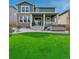 Beautiful backyard with a lush lawn, hot tub, covered patio, and stone fire pit at 1066 S Eaton Park Ct, Aurora, CO 80018