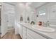 Bright and clean bathroom featuring double sinks, white cabinets, and a separate tub and shower at 1066 S Eaton Park Ct, Aurora, CO 80018
