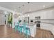Bright, modern kitchen features white cabinets, stainless steel appliances, and a stylish island with seating at 1066 S Eaton Park Ct, Aurora, CO 80018