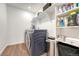 Functional laundry room with modern appliances and ample storage shelving for detergents and cleaning supplies at 1066 S Eaton Park Ct, Aurora, CO 80018