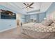 Inviting main bedroom featuring a tray ceiling, ceiling fan, and a view of the attached sitting area at 1066 S Eaton Park Ct, Aurora, CO 80018