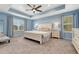 Serene main bedroom with tray ceiling, ceiling fan, and large windows that offer abundant natural light at 1066 S Eaton Park Ct, Aurora, CO 80018