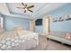 Bright main bedroom showcasing a tray ceiling, ceiling fan, and convenient access to an en-suite bathroom at 1066 S Eaton Park Ct, Aurora, CO 80018
