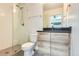 Modern bathroom featuring a walk-in shower with glass door, sleek vanity, and contemporary fixtures at 5530 W 11Th Pl, Lakewood, CO 80214