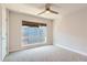 Bright bedroom features a neutral color palette, ceiling fan, and window with a view of the neighborhood at 5530 W 11Th Pl, Lakewood, CO 80214