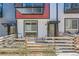 Charming townhouse exterior with a metal awning, decorative fencing and vibrant red accents at 5530 W 11Th Pl, Lakewood, CO 80214
