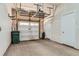 Spacious garage with an overhead storage rack, white door, and green trash receptacle at 5530 W 11Th Pl, Lakewood, CO 80214