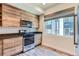 Bright kitchen with modern island, stainless appliances, and hardwood cabinets at 5530 W 11Th Pl, Lakewood, CO 80214