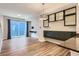 Open-concept living room featuring hardwood floors, modern lighting, and sliding glass doors to a balcony at 5530 W 11Th Pl, Lakewood, CO 80214