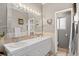 Bright bathroom with dual sinks, tile countertop, updated mirror and lighting, and storage at 6303 W Exposition Ave, Lakewood, CO 80226