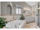 Soaking tub with jets surrounded by tile walls, plus double sinks, in the spacious primary bathroom at 6303 W Exposition Ave, Lakewood, CO 80226