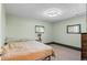 A carpeted bedroom features two windows, light green walls, and a queen bed frame with no headboard at 6303 W Exposition Ave, Lakewood, CO 80226