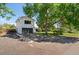 View of a two-story home with an attached garage and mature landscaping at 6303 W Exposition Ave, Lakewood, CO 80226