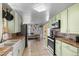 Well-lit kitchen featuring tiled floors, vintage-style cabinets, countertops, and modern appliances at 6303 W Exposition Ave, Lakewood, CO 80226