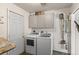 Bright laundry area features a washer, dryer, cabinets for storage, and cleaning supplies organization at 6303 W Exposition Ave, Lakewood, CO 80226