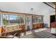Relaxing sunroom featuring wood paneled walls, ample windows, comfortable seating, and outdoor views at 6303 W Exposition Ave, Lakewood, CO 80226