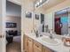 Well-lit bathroom features double sinks, neutral decor, and is conveniently located near a bedroom at 13891 Muirfield Ct, Broomfield, CO 80023