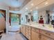 This primary bathroom features double sinks, wooden cabinetry, a soaking tub, and a separate walk-in shower at 13891 Muirfield Ct, Broomfield, CO 80023