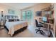 Bright bedroom with ample natural light, includes a bed, desk and shelving unit, perfect for work or relaxation at 13891 Muirfield Ct, Broomfield, CO 80023