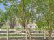 View of the community pool and clubhouse framed by lush trees and a white fence at 13891 Muirfield Ct, Broomfield, CO 80023