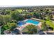 A lovely aerial shot showcases a neighborhood pool and recreation area surrounded by trees at 13891 Muirfield Ct, Broomfield, CO 80023
