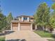Charming two-story home features a three-car garage, well-manicured lawn, and mature shade tree at 13891 Muirfield Ct, Broomfield, CO 80023