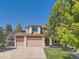 Charming two-story home features a three-car garage, well-manicured lawn, and mature shade tree at 13891 Muirfield Ct, Broomfield, CO 80023