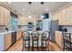 Bright kitchen with a center island, stainless steel appliances, hardwood floors and pendant lighting at 13891 Muirfield Ct, Broomfield, CO 80023