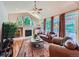 Cozy living room featuring a fireplace, ceiling fan, hardwood floors, and lots of natural light at 13891 Muirfield Ct, Broomfield, CO 80023