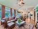 Spacious living room area leading to an open-concept kitchen, complete with hardwood floors and large windows at 13891 Muirfield Ct, Broomfield, CO 80023