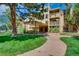 Well-manicured lawn and sidewalk lead to this building, with a covered entry and multiple levels at 1302 S Parker Rd # 229, Denver, CO 80231