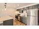 Contemporary kitchen boasts stainless appliances, gray cabinets and a breakfast bar at 1302 S Parker Rd # 229, Denver, CO 80231