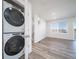 View of the living area with adjacent laundry closet, wood look floors and natural light at 46537 Avery Ln, Bennett, CO 80102