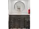 Elegant bathroom vanity with a large round mirror and modern fixtures over unique patterned tile flooring at 7500 E Dartmouth Ave # 8, Denver, CO 80231