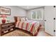 Cozy bedroom featuring striped bedding, wood floors, bedside table, and natural light at 7500 E Dartmouth Ave # 8, Denver, CO 80231