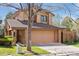 View of home featuring an attached two-car garage and landscaped front yard at 7500 E Dartmouth Ave # 8, Denver, CO 80231