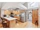 Spacious kitchen featuring a stainless refrigerator, breakfast bar, and adjacent pantry with barn door at 7500 E Dartmouth Ave # 8, Denver, CO 80231