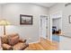 Cozy sitting room with patterned armchair, hardwood floors, and view into office space at 7500 E Dartmouth Ave # 8, Denver, CO 80231