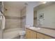 Well-lit bathroom featuring a shower, tub combo, and tile backsplash at 18997 E 51St Pl, Denver, CO 80249