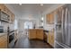 Well-lit kitchen with stainless steel appliances, wooden cabinets, and tiled flooring at 18997 E 51St Pl, Denver, CO 80249