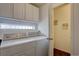 Efficient laundry room features washer, dryer, storage cabinets, and a convenient layout at 18997 E 51St Pl, Denver, CO 80249