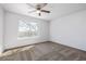 This bright bedroom features neutral carpet, a ceiling fan, and a large window at 8199 Welby Rd # 501A, Denver, CO 80229