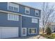 View of the exterior of a two-story home with a garage and blue siding at 8199 Welby Rd # 501A, Denver, CO 80229