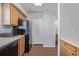 A kitchen featuring wood cabinets and black appliances next to a hall closet and a bathroom at 8199 Welby Rd # 501A, Denver, CO 80229