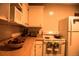 Cozy kitchen with white appliances, wooden countertops, microwave and dish towels hanging on the oven at 6213 Gray St, Arvada, CO 80003