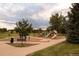 Gathering-friendly neighborhood playground with swings, slides, and play structures for children, surrounded by green space and trees at 6213 Gray St, Arvada, CO 80003