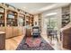 Home office with custom built-in shelving, hardwood floors, and natural light from a large arched window at 11070 Meade Ct, Westminster, CO 80031